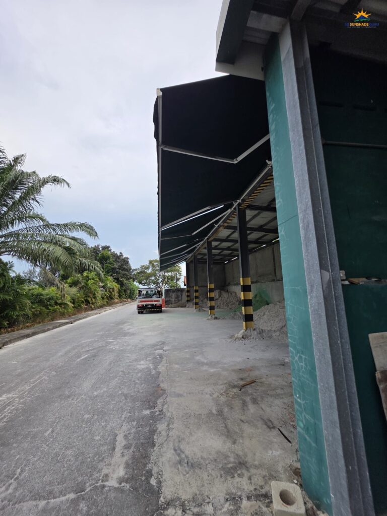 Heavy-duty retractable awning extended over an industrial storage area for weather protection in Singapore.