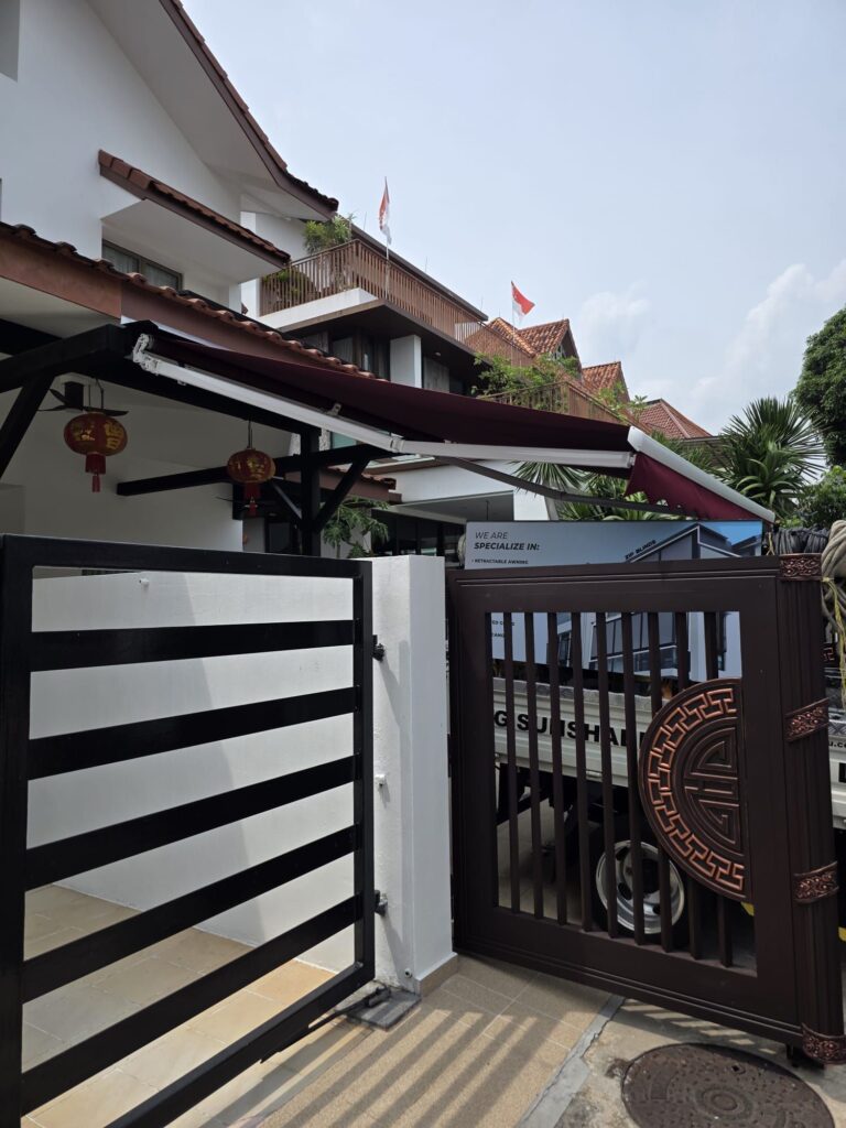 Retractable awning extending over a house driveway for sun protection