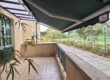 Extended retractable awning providing shade for an outdoor balcony
