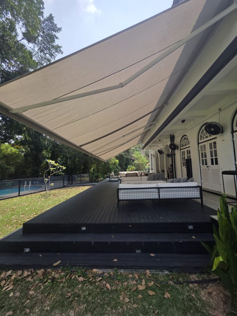 Large retractable awning providing shade over an outdoor lounge area