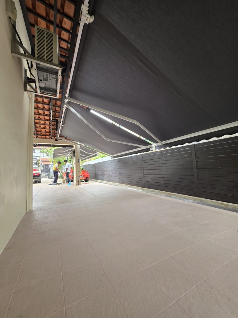 Side view of a black retractable awning extending from a residential house