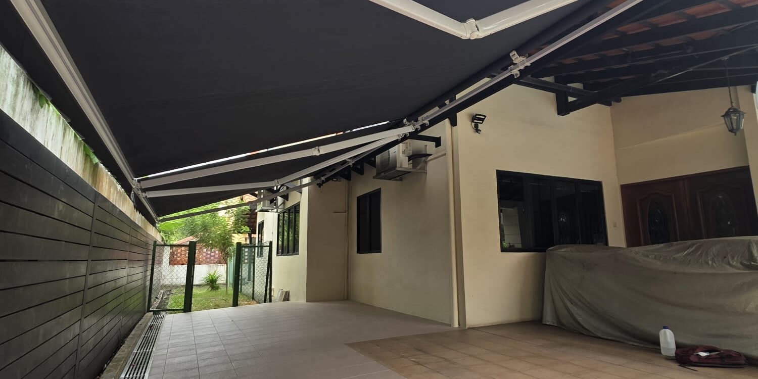 Black retractable awnings providing shade over a spacious residential car porch
