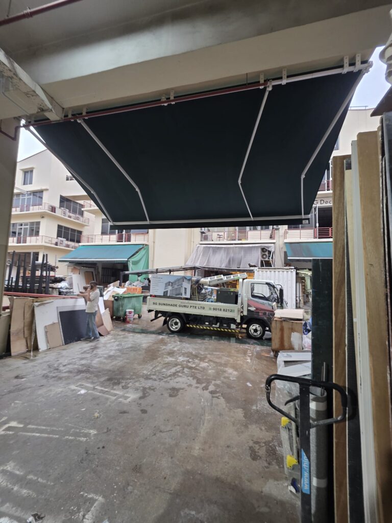 Black retractable awning shading a home patio and garden area