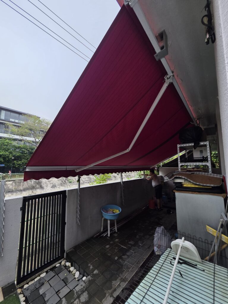 Green retractable awning installed above the entrance of a commercial unit