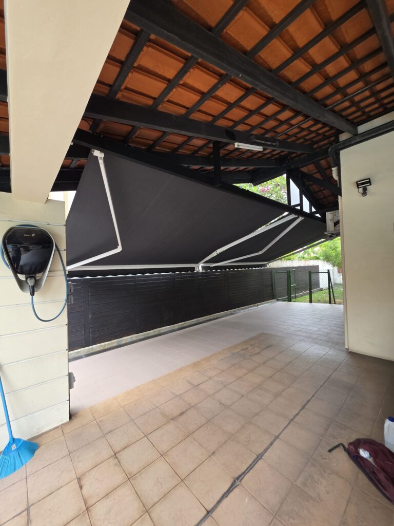 Black retractable awnings installed along a covered residential driveway